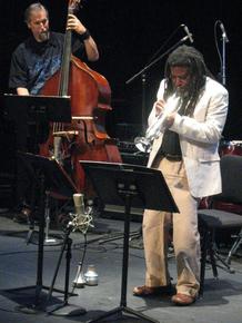 Wadada_leo_smith_in_front_of_projection_of_lbj_signing_voting_rights_act__1964_ten_freedom_summers__october__2011_copyright_2011_lyn_horton_depth1